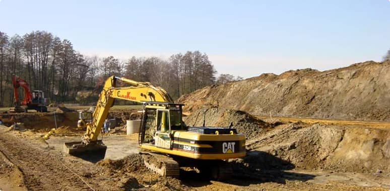 Kettenbagger bei Erdarbeiten auf einer sandigen Baustelle
